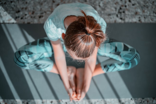 woman doing a mindful movement meditation while sitting down