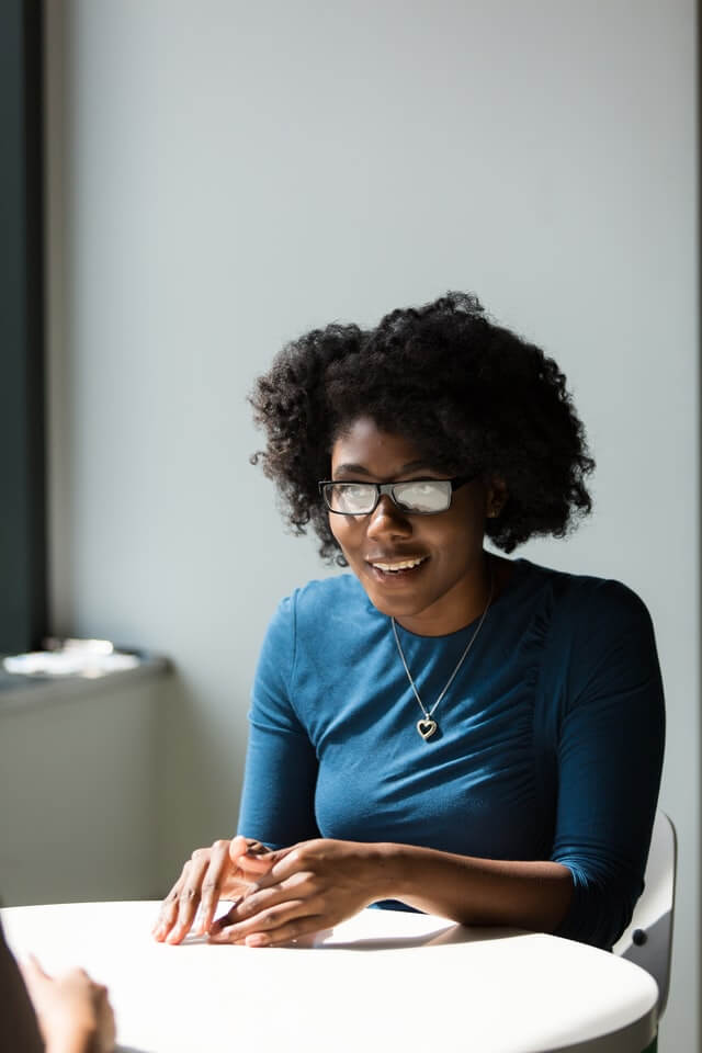 woman sitting down and practicing skills of assertiveness