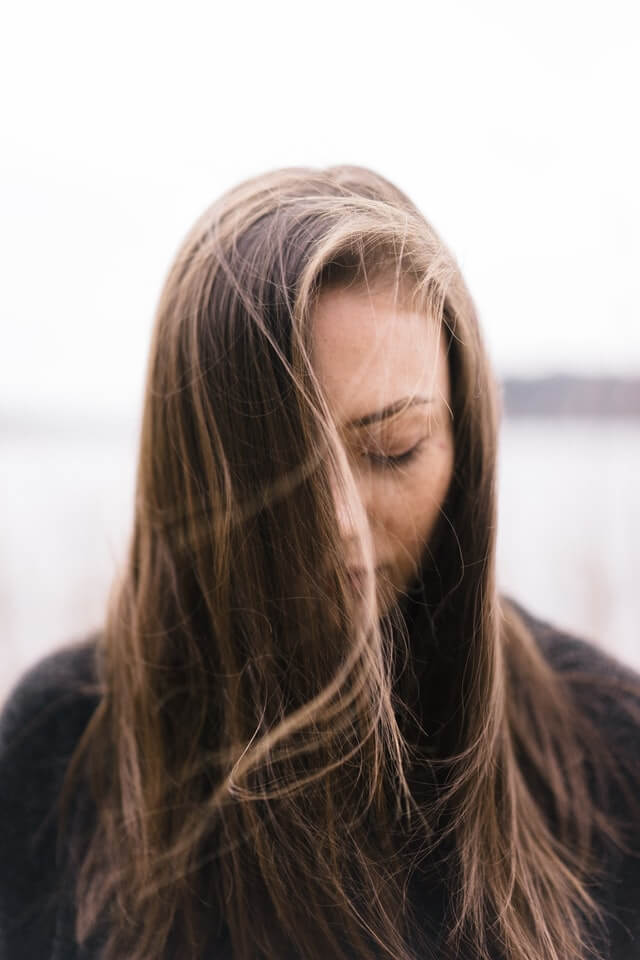 young adult woman with social anxiety feeling shy and looking down