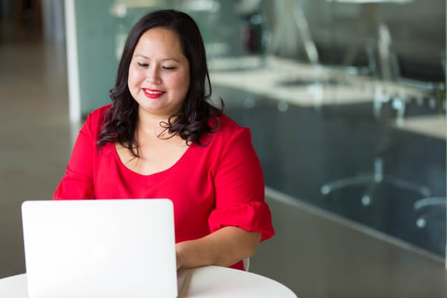 adult woman typing on a laptop computer and adjusting to a new job