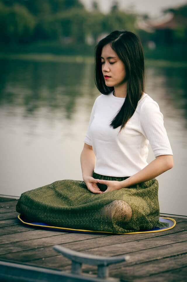 young adult woman with anxiety sitting down in a meditation practice