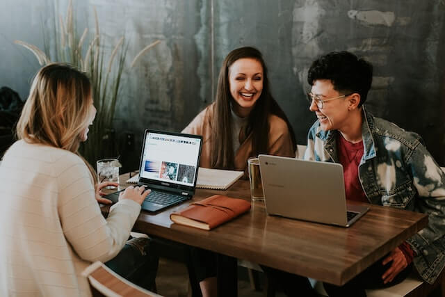 Young adults sitting around a table talking