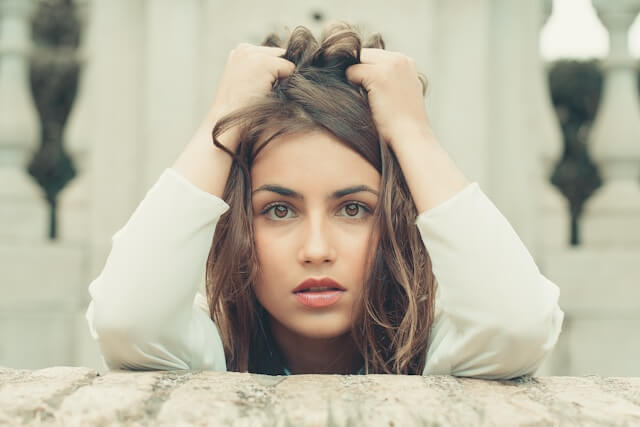 Adult woman with hands in her hair managing anticipatory anxiety